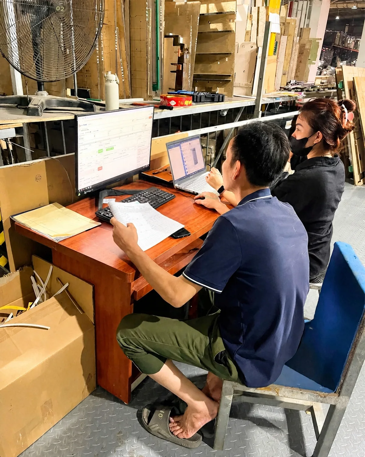 Nhân viên đối chiếu sổ kiểm tra chất lượng với ControlMES tại xưởng